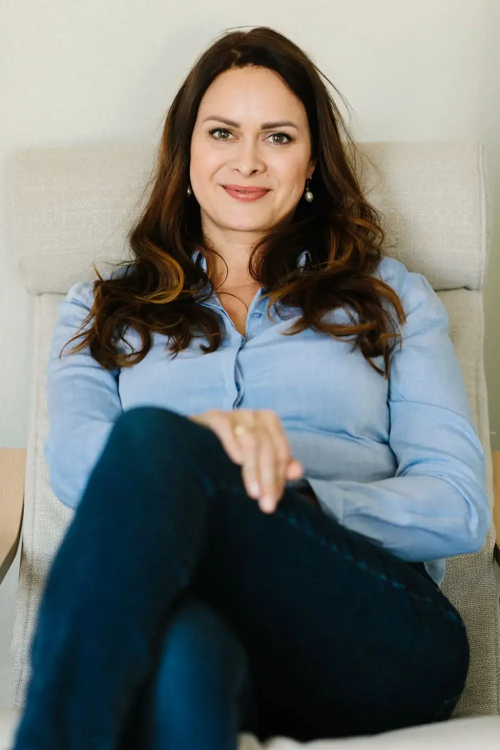 Carmen Seemann sitzt in einem hellen Sessel in ihrer Praxis in Mainz